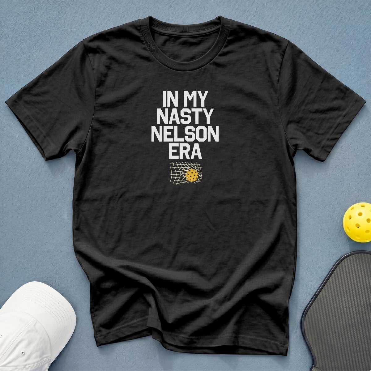 Black t-shirt with "IN MY NASTY NELSON ERA" text and pickleball net graphic.