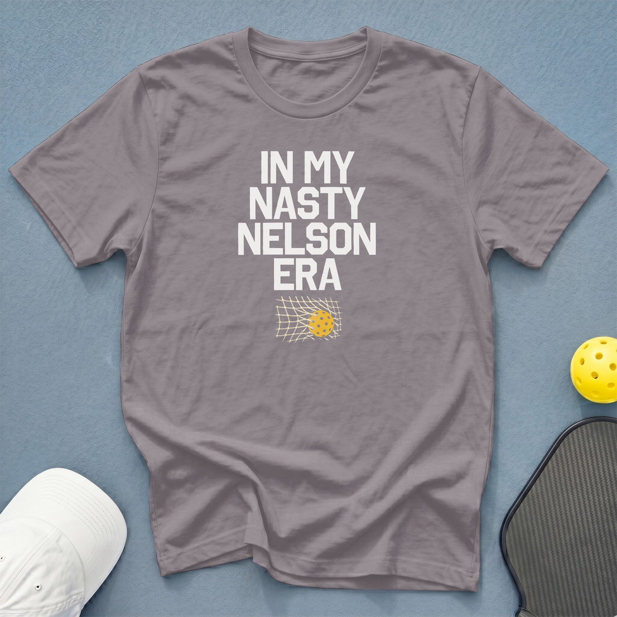 Gray t-shirt with "In My Nasty Nelson Era" text and pickleball net graphic.