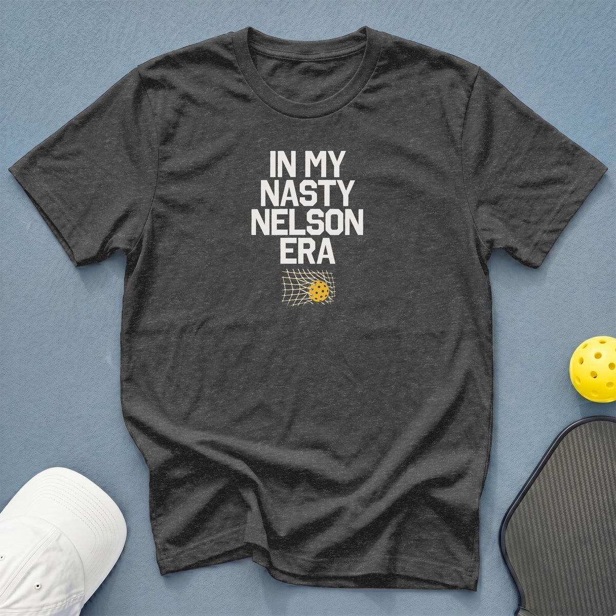 Dark grey t-shirt with white text "IN MY NASTY NELSON ERA" and pickleball graphic.