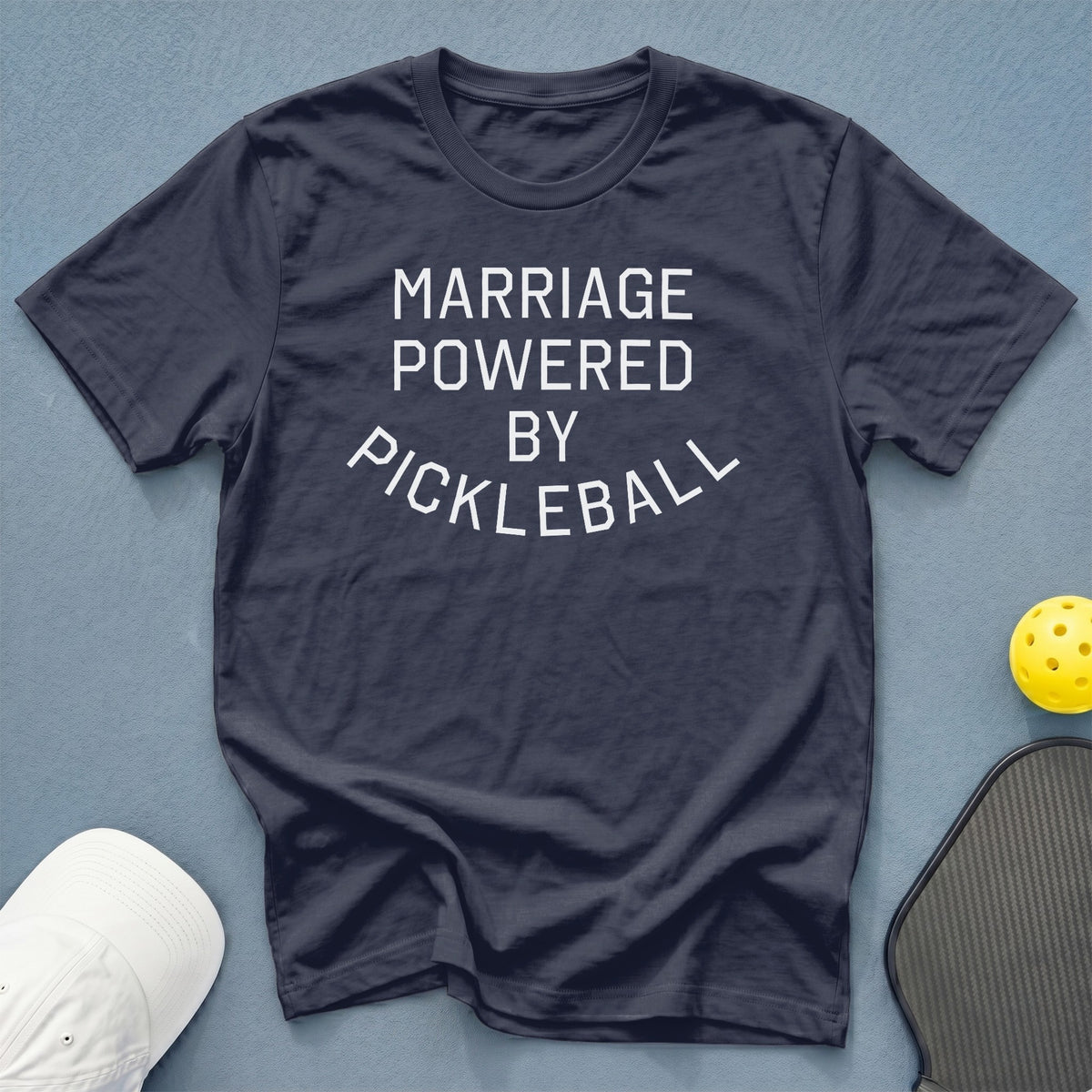 Dark blue t-shirt with white text "MARRIAGE POWERED BY PICKLEBALL".