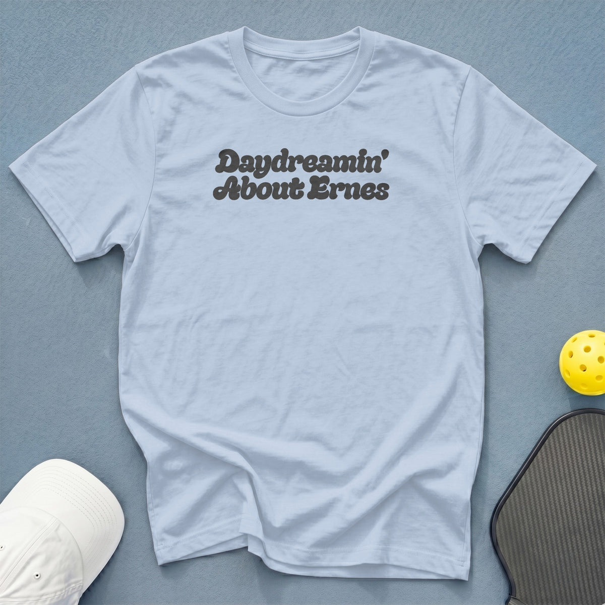 Light blue t-shirt with "Daydreamin' About Ernes" text, pickleball paddle and ball.
