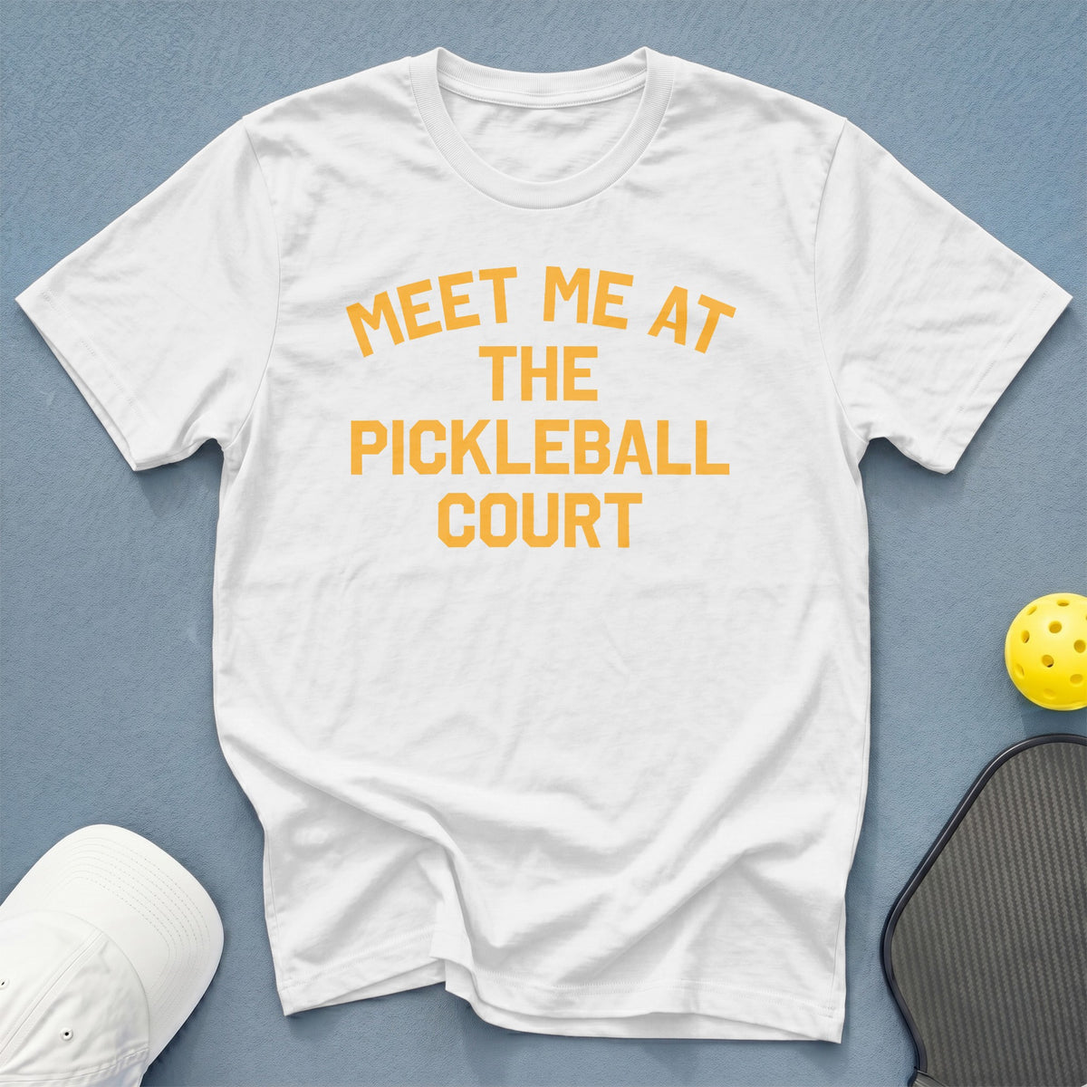 White t-shirt with orange text "MEET ME AT THE PICKLEBALL COURT."