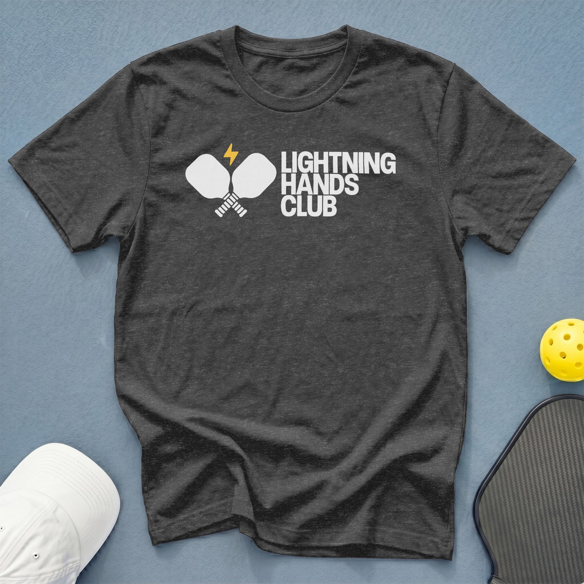 Dark grey t-shirt with white "LIGHTNING HANDS CLUB" text and pickleball paddles.