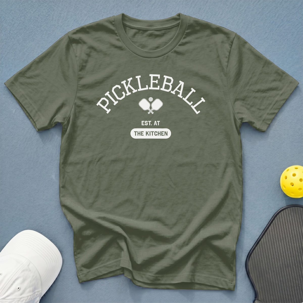 Olive green t-shirt with "Pickleball Est. At The Kitchen" text and graphic.