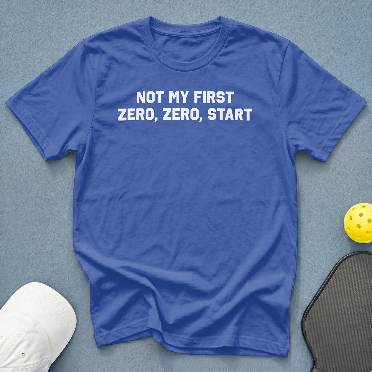 Blue t-shirt with white text reading "NOT MY FIRST ZERO, ZERO, START".