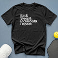 Black t-shirt with white text: Eat & Sleep & Pickleball & Repeat.