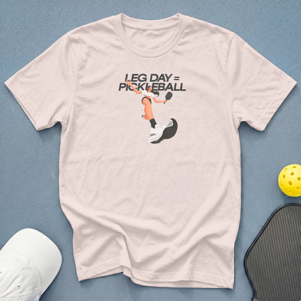 Light pink t-shirt with "LEG DAY = PICKLEBALL" graphic and pickleball gear.