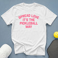White t-shirt with pink text that says "SPREAD LOVE IT'S THE PICKLEBALL WAY".
